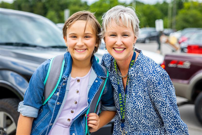 A student and principal smile